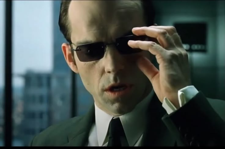 Agent Smith from the Matrix movies removing his sunglasses